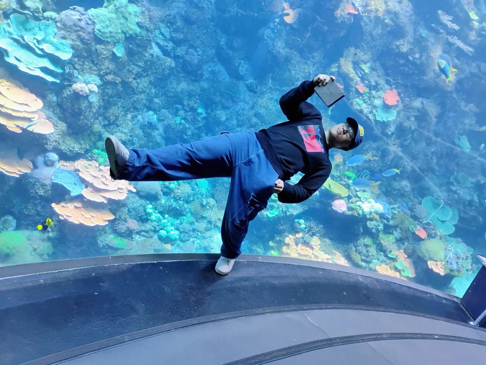 Nathaniel Mapaye posing in front of an aquarium
